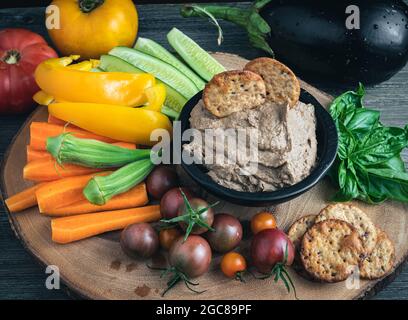 Hummus aus schwarzen Bohnen und Auberginen mit einer Vielzahl von frischem rohem Gemüse. Stockfoto