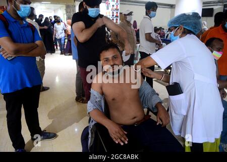 Ein Gesundheitsmitarbeiter impft einen Mann mit einer Dosis des Impfstoffs Moderna COVID19 während einer Massenimpfkampagne im Shamoli-Impfzentrum in Dhaka, Bangladesch, am 7. August 2021. Nach Angaben der Generaldirektion für Gesundheitsdienste in Bangladesch (DGHS) startet das landesweite Massenimpfungsprogramm seine Impfkampagne, die darauf abzielt, 3.5 Millionen Menschen innerhalb von sechs Tagen zu injizieren. Bangladesch hat seit Beginn der Pandemie fast 1.31 Millionen Coronavirus-Infektionen und 21,638 Todesfälle verzeichnet. Stockfoto