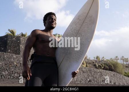 Surfer african american man hält Longboard vor Surf Session - Extreme Sport Lifestyle Stockfoto