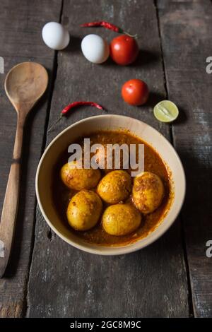 Draufsicht auf Eiermasala oder Eiercury, zubereitet mit Zwiebeln, Knoblauch und einer Mischung aus indischen Gewürzen in einer Schüssel. Stockfoto