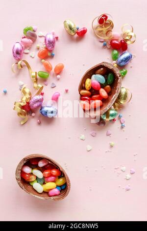 Schokolade Ostereier und andere Süßigkeiten auf rosa Hintergrund. Party-Dessert Stockfoto