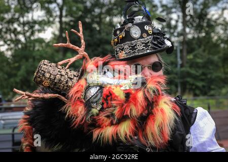 Schiffshebewerk Henrichenburg, Waltrop, Deutschland, 7. August 2021. Zwei Enthusiasten haben ihre flauschigen Drachenfreunde mitgebracht. Steampunk-Fans und Besucher, viele in voll retro-futuristischen Kostümen und Steampunk-Outfits, treffen sich zum ´Steampunk Jubilee Market´ Festival am historischen Wahrzeichen der Henrichenburg-Seilbahn, Teil des Waltrop-Schlossparks am Dortmund-Ems-Kanal, heute ein Industriemuseum. Das alte eiserne Gerüst, die Kontrolltürme, Maschinenhäuser und das Museum bilden eine stimmungsvolle Kulisse für das Festival.Quelle: Imageplotter/Alamy Live News Stockfoto