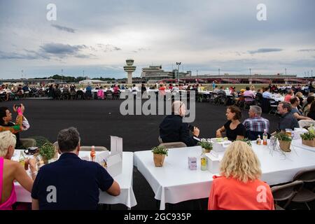 Berlin, Deutschland. August 2021. Die Teilnehmer des „Freedom Dinner“ sitzen an Tischen auf der Startbahn des ehemaligen Flughafens Tegel. Die Wirtschaftsverwaltung, die Senatskanzlei, die Messe Berlin und das Tourismusmarketing hatten zur Open-Air-Veranstaltung eingeladen. Quelle: Paul Zinken/dpa/Alamy Live News Stockfoto