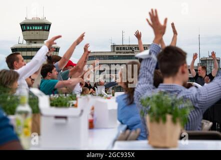 Berlin, Deutschland. August 2021. Die Teilnehmer des „Freedom Dinner“ sitzen an Tischen auf der Startbahn des ehemaligen Flughafens Tegel. Die Wirtschaftsverwaltung, die Senatskanzlei, die Messe Berlin und das Tourismusmarketing hatten zur Open-Air-Veranstaltung eingeladen. Quelle: Paul Zinken/dpa/Alamy Live News Stockfoto