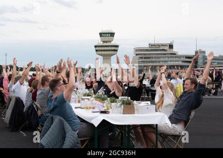 Berlin, Deutschland. August 2021. Die Teilnehmer des „Freedom Dinner“ sitzen an Tischen auf der Startbahn des ehemaligen Flughafens Tegel. Die Wirtschaftsverwaltung, die Senatskanzlei, die Messe Berlin und das Tourismusmarketing hatten zur Open-Air-Veranstaltung eingeladen. Quelle: Paul Zinken/dpa/Alamy Live News Stockfoto