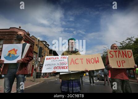 Cambridge, Großbritannien. August 2021. Protestierende halten Plakate während der Demonstration.Extinction Rebellion Aktivisten blockierten eine große Straße in Cambridge in fünf Minuten Abständen, um den Verkehr zu stoppen und die extremen Wetterereignisse aus diesem Jahr und die Art und Weise, wie sich das Klima verändert, hervorzuheben. Kredit: SOPA Images Limited/Alamy Live Nachrichten Stockfoto