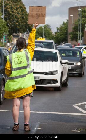 Cambridge, Großbritannien. August 2021. Ein Protestler hält während der Demonstration ein Plakat.Aktivisten des Extinction Rebellion blockierten in fünf Minuten eine große Straße in Cambridge, um den Verkehr zu stoppen und die extremen Wetterereignisse aus diesem Jahr und die Art und Weise, wie sich das Klima verändert, hervorzuheben. Kredit: SOPA Images Limited/Alamy Live Nachrichten Stockfoto