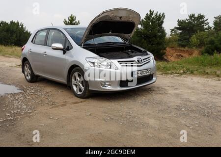 Dnipro, Ukraine - 30. Juli 2021: Toyota Auris 2012 Silber Farbe mit offener Haube. Sommerlicher Regen Stockfoto