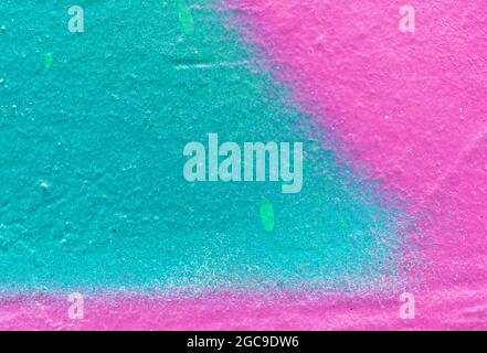 Makro-Nahaufnahme einer rosa und türkisgrünen Sprühfarbe mit Spritzern. Abstrakter Vollformat strukturierter, spritzgetragener Graffiti-Hintergrund mit Platz für Kopien. Stockfoto