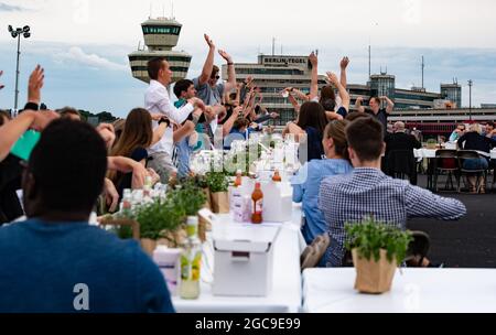 Berlin, Deutschland. August 2021. Die Teilnehmer des „Freedom Dinner“ sitzen an Tischen auf der Startbahn des ehemaligen Flughafens Tegel. Die Wirtschaftsverwaltung, die Senatskanzlei, die Messe Berlin und das Tourismusmarketing hatten zur Open-Air-Veranstaltung eingeladen. Quelle: Paul Zinken/dpa/Alamy Live News Stockfoto