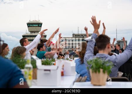 Berlin, Deutschland. August 2021. Die Teilnehmer des „Freedom Dinner“ sitzen an Tischen auf der Startbahn des ehemaligen Flughafens Tegel. Die Wirtschaftsverwaltung, die Senatskanzlei, die Messe Berlin und das Tourismusmarketing hatten zur Open-Air-Veranstaltung eingeladen. Quelle: Paul Zinken/dpa/Alamy Live News Stockfoto