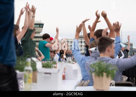 Berlin, Deutschland. August 2021. Die Teilnehmer des „Freedom Dinner“ sitzen an Tischen auf der Startbahn des ehemaligen Flughafens Tegel. Die Wirtschaftsverwaltung, die Senatskanzlei, die Messe Berlin und das Tourismusmarketing hatten zur Open-Air-Veranstaltung eingeladen. Quelle: Paul Zinken/dpa/Alamy Live News Stockfoto