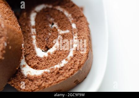 Schokoladen-Biskuitrolle mit Vanillegeschmack, Schweizer Schokoladenrolle, wirbelter Kuchen Stockfoto