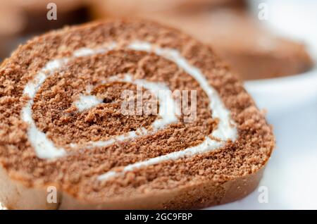 Schokoladen-Biskuitrolle mit Vanillegeschmack, Schweizer Schokoladenrolle, wirbelter Kuchen Stockfoto