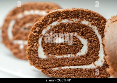 Schokoladen-Biskuitrolle mit Vanillegeschmack, Schweizer Schokoladenrolle, wirbelter Kuchen Stockfoto