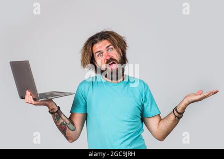 Bärtiger Mann mit Laptop. Digitales Gerät. Seriöser Geschäftsmann mit Computer. Arbeiten Sie von zu Hause aus. Stockfoto