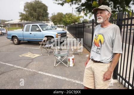 Susanville, Usa. August 2021. Der Evakuierte Rob Poindexter aus Westwood, einer kleinen Gemeinde östlich von Lae Amador, blickt auf den steigenden Rauch des Dixie-Feuers, während er auf die Rückkehr der Behörden wartet, während er im Lassen County Run Evakuierungszentrum an der Lassen High School in Susanville Schutz einnahm. Kalifornien während des Brandes von Dixie am 7. August 2021. Foto von Peter DaSilva/UPI Credit: UPI/Alamy Live News Stockfoto