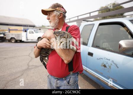 Susanville, Usa. August 2021. Der Evakuierte Jim Cabral aus Westwood, einer kleinen Gemeinde östlich des Lake Amador, tröstet seine Katze Jeff, während sie auf eine Entmachtung durch die Behörden warten, um nach Hause zurückzukehren, während sie im Lassen County Run Evakuierungszentrum an der Lassen High School in Susanville Schutz einräumte, Kalifornien während des Brandes von Dixie am 7. August 2021. Foto von Peter DaSilva/UPI Credit: UPI/Alamy Live News Stockfoto