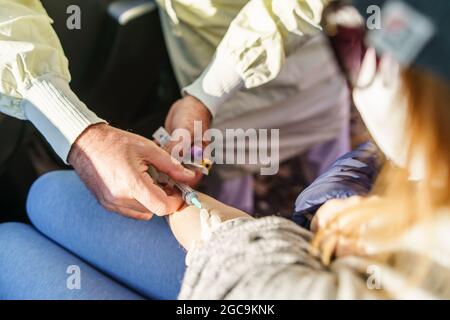 Nahaufnahme eines unbekannten medizinischen Technikers, der Blutproben vom Patienten entnommen hat Stockfoto