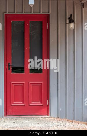 Rote Tür, viertafelige Tür, verglaste Tür, viktorianische Tür, Tür in der Wand, Holztür, antike Tür, altmodische Tür, rot gestrichene Tür, verglaste Paneele. Stockfoto