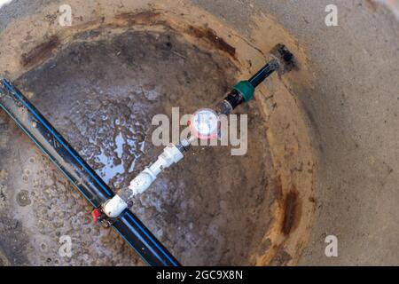 Anapa, Russland-07.24.2021:Wasserzähler in einem unterirdischen Brunnen. Pipeline für ein Landhaus. Stockfoto