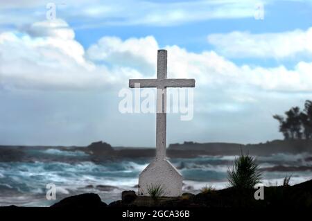 Big Island of Hawaii hat eine zerklüftete Windseite. Das eineinsitzige Kreuz liegt an der Küste mit Blick auf eine felsige und gefährliche Bucht. Stockfoto