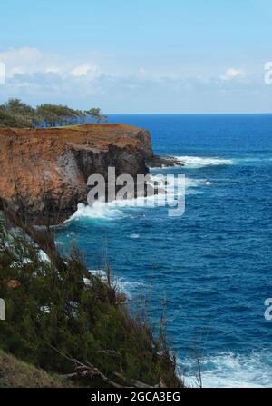 Der Alenuihaha-Kanal ist an der Küste der Big Island von Hawaii azurblau. Wellen schlagen gegen die hohen Felsklippen. Stockfoto