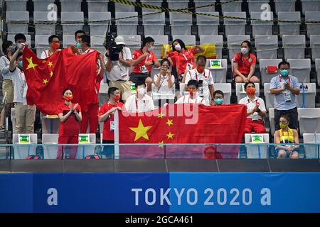 Chinesische Anhänger auf der Tribüne mit chinesischer Flagge, Banner. Synchronisiertes Schwimmen, künstlerisches Schwimmen Team Freie Routine. Aquatics Center am 7. August 2021, Olympische Sommerspiele 2020, ab 23. Juli. - 08.08.2021 in Tokio/Japan. Stockfoto