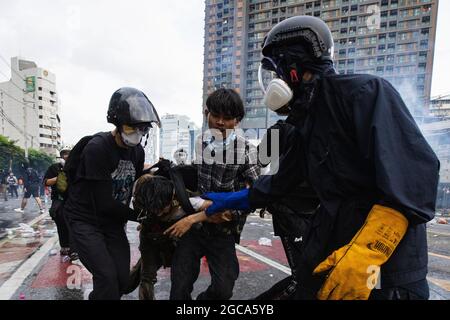 Bangkok, Thailand. August 2021. Demonstranten, die während der Demonstration einen verletzten Kollegen an der Kreuzung von DIN Daeng trugen.die pro-demokratische „Freie Jugend“-Gruppe, die den Rücktritt des thailändischen Premierministers und die Reform der Monarchie forderte, kündigte ihren Plan an, den Großen Palast zu besuchen, was zu einer Konfrontation zwischen Demonstranten und der Bereitschaftspolizei führen würde. Kredit: SOPA Images Limited/Alamy Live Nachrichten Stockfoto