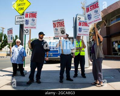 Reno, Nevada, USA. August 2021. Während des Streiks halten Demonstranten Streikzeichen an einer Bushaltestelle.Busfahrer streiken, nachdem die Gewerkschaftsnegationen gescheitert sind. Die Stadt ist ohne öffentliche Verkehrsmittel. (Bild: © Ty O'Neil/SOPA Images via ZUMA Press Wire) Stockfoto