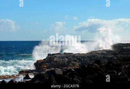 Die Erkundung der windstillen Seite der Big Island von Hawaii führt Sie zur Kapoho Coast, wo Wellen gegen die felsigen Klippen plätschern und krachen. Stockfoto