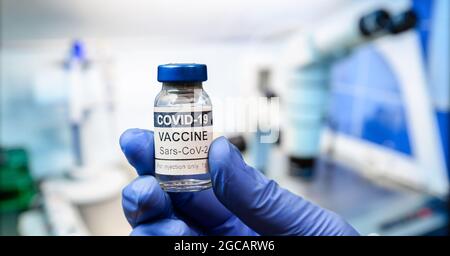 COVID-19-Impffläschchen in der Hand des Forschers im Labor hält der Arzt die Impffläschchen des Coronavirus aus der Nähe. Konzept der Impfung, Wiedereröffnung, Impfstoffinjektion Stockfoto