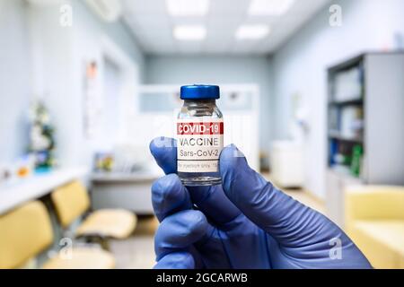 COVID-19-Impffläschchen in ärztlicher Hand in der Klinik hält der Arzt eine Flasche mit Coronavirus-Impfstoff. Konzept der Impfung, Immunisierung, Impfstoffinjektion und Stockfoto