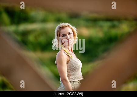 Elegante Frau 48 Jahre alt geht im Sommer im Garten. Stockfoto