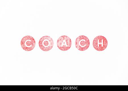 Roter Farbgummi-Stempel im Wortcoach auf weißem Papierhintergrund Stockfoto