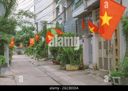 Flaggen entlang einer kleinen Straße in Hanoi. Nationale vietnamesische Flaggen in Häusern engen Wohnstraße gesetzt. Patriotismus der Bürger während der Feier von Stockfoto