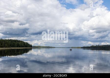 Ein Boot in einem ruhigen See im Sommer in Finnland Stockfoto