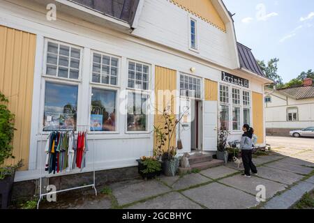 LOVIISA, FINNLAND - 04-08-2021: Asiatische Frau und ihr Pug Dog suchen in einer Souvenir- und Lifestyle-Boutique Krinti in der Niederen Altstadt von Loviisa, Finnland. Stockfoto