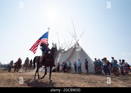 Nez Perce Reiter in einer Prozession um ein Langhaus in am'saaxpa, Wallowa Valley, Oregon. Stockfoto