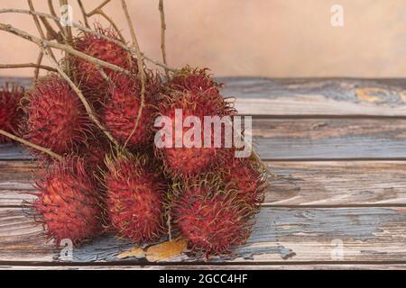 Lokale Früchte genannt Rambutan, rote Variante, die am häufigsten ist. Rambutan ist eine tropische Frucht aus der Familie der Speckbeeren. Selektiver Fokus. Verschwommener Rückstand Stockfoto