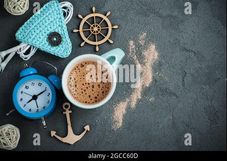 Frühstückskonzept, Becher heiße Schokolade oder Kakao, Wecker auf Betonhintergrund Stockfoto