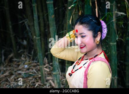 Mädchen lächelndes Gesicht isoliert in traditionellen tragen auf dem Festival mit verschwommenem Hintergrundbild gekleidet wird anlässlich der Bihu in assam indien aufgenommen. Stockfoto