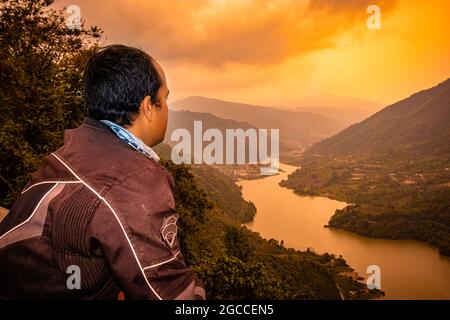 Der Mann, der morgens aus einem Flachwinkelbild die unberührte natürliche Bergtalansicht betrachtet, wird am Potenblickpunkt ziro arunachal pradesh india aufgenommen. Stockfoto