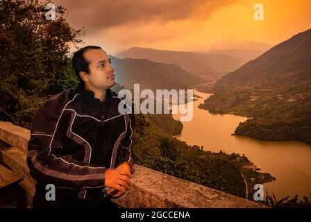 Der Mann, der morgens aus einem Flachwinkelbild die unberührte natürliche Bergtalansicht betrachtet, wird am Potenblickpunkt ziro arunachal pradesh india aufgenommen. Stockfoto