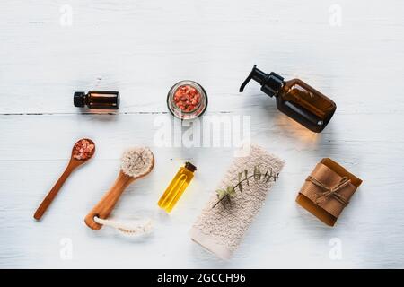 Badaccessoires und Naturkosmetik, himalaya-Rosa-Salz im Glas, ätherische Öle auf weißem Holztisch. Zero Waste Konzept. Draufsicht, flach liegend Stockfoto