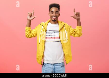 Studioaufnahme eines gutaussehenden, zufrieden und zufrieden aussehenden afroamerikanischen bärtigen männlichen Models, das die Hände hochhebt und mit Freude am Stehen lächelt Stockfoto