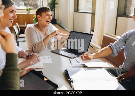 Fröhliches kreatives Team, das neue Ideen diskutiert. Lächelnde Kollegen in der Projektdiskussion. Stockfoto