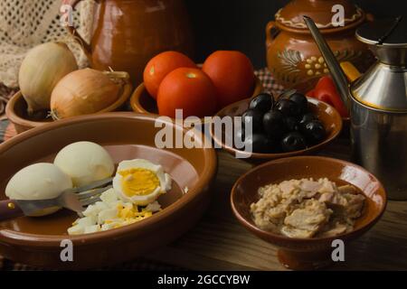 Stillleben mit Tomaten, Oliven, gekochten Eiern, Thunfisch, Olivenöl zusammen mit anderen Zutaten zu kochen Moje, Mojete, spanische Küche aus Murcia, Albacete in Stockfoto