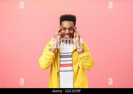 Besorgt intensiven afroamerikanischen Kerl kann nicht mit Druck zucken Zähne schließen Augen halten Finger auf Schläfen nicht konzentriert unter Stress Stockfoto