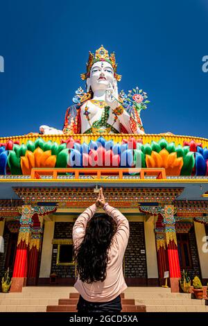 Junge Mädchen beten vor der buddhistischen bunten Göttin Statue mit blauem Himmel am Morgen Bild wird im Lumla taradevi Kloster tawang arunachal p aufgenommen Stockfoto